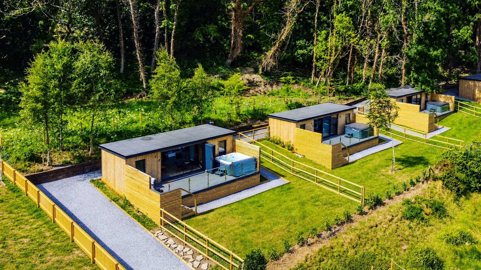 Gower Coast Cabins from above — cabins and hot tubs set in woodland